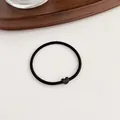 Minimalist high-elasticity black hair tie with a matte black heart-shaped accent charm - Black