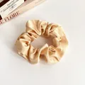 Eleganter champagnerfarbener Satin-Scrunchie im französischen Stil mit seidigem Glanz - Hautfarben