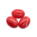 Détail macro de trois pierres cabochons ovales polies à rayures rouges et blanches DIY - 6X8mm / Agate rouge