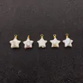 Fünf sternförmige Barockperlen-Anhänger mit goldenen Ösen auf schwarzem Hintergrund - 12x15mm