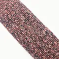 Macro detail of faceted natural rhodonite beads showing pink and black textures - Faceted Round Beads / Rhodonite with Black Lines
