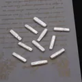 Macro-opname van witte barokke rechthoekige parels met iriserende glans voor DIY-sieraden - 5x22-6x23mm / Parelwit