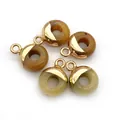 Detail van donutvormige hangers van natuursteen met vergulde ophanglussen - Ronde Ring / Gele Chalcedoon
