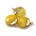 Close-up of three faceted yellow natural stone pendants with gold metal caps for DIY jewelry - Topaz