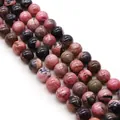 Macro shot of natural pink rhodonite round loose beads with unique stone textures for DIY jewelry - 4mm
