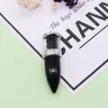 Macro detail of bullet shaped stone pendant with silver metal top and black crystals - Black Agate