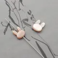 Macro shot of pink rabbit-shaped natural shell beads showing horizontal hole detail - Vertical Hole Rabbit Head / Pink