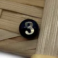 Macro shot of circular black shell bead with gold number three for DIY jewelry - Number 3 / Black