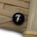 Macro view of a black round bead with golden number 7 for DIY jewelry making - Number 7 / Black