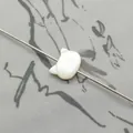Detailed view of white rabbit-shaped shell bead with natural pearl luster for DIY jewelry - Vertical Hole Cat Head / White