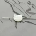Macro view of cat-shaped white mother of pearl bead showing natural iridescent texture - Horizontal Hole Cat Head / White
