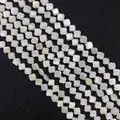 Vista macro de cuentas de nácar blancas en forma de trébol con brillo iridiscente - Flor de Cuatro Pétalos (6mm)