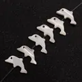 Makro-Detail von sechs delfinförmigen Perlmuttperlen mit irisierendem Glanz auf schwarzem Band - Delfinform / Klein