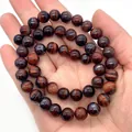 Polished natural red tiger eye stone beaded bracelet with glossy finish on a palm - 6mm / Red Tiger's Eye