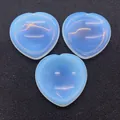 Pierres de guérison en opalite en forme de cœur avec éclat bleu sur fond noir texturé - Opalite (N° 19)