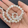 Strand of natural white baroque freshwater pearls held in hand for jewelry making - 4-5mm / White (No. 1)