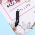 Polished black natural stone horn pendant with silver metal clasp on a floral card - Black Agate