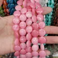 Hand holding pink flat round natural stone beads for DIY jewelry making - 16x16x6mm / Light Pink Stone (No. 19)