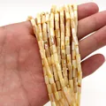 Close-up of natural shell cylinder beads with pearlescent luster for DIY jewelry - Cylinder Style (1006-B220827015) / 4x8mm (11g) / No. 2 (Creamy Yellow)