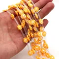 Macro detail of 10mm orange daisy shell beads and transparent spacer tubes for DIY jewelry - No. 5 (Orange)