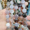 Hand holding stacked flat circular natural grey agate loose beads for DIY jewelry - 16x16x6mm / Grey Agate