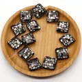 Detailed view of square mosaic shell beads with iridescent inlay on a wooden tray - Black Shell