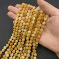 Faceted natural yellow stone beads in 6/8/10mm held by hand for DIY jewelry making - Small / Topaz