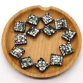Macro view of square natural shell mosaic beads for DIY jewelry making on wood tray - Abalone Shell