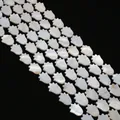 Vista macro de cuentas de nácar blanco en forma de mano hamsa para creación de joyas - Forma de Mano de Hamsa
