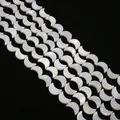 Macro detail of crescent moon shell beads with natural iridescent white mother of pearl luster - Moon