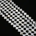 Detailed close-up of natural white mother of pearl clover shaped loose beads on black backdrop - Four-leaf Clover Shape