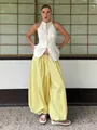Women's two-piece set featuring a white halter top and bright yellow wide-leg pants - S / Yellow