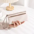 Detailansicht beige Ledergeldbörse mit Lychee-Struktur, Doppelreißverschluss und Handschlaufe - Long Litchi Texture / Cremeweiß