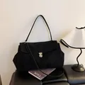 Schwarze Schultertasche aus Wildleder mit Kontrastnähten und Metallschnalle - Schwarz