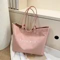Pink suede tote bag featuring white TOTE BAG print and comfortable long handles - Pink