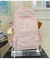 Detail eines rosa Schulrucksacks mit Stickerei, Schleife und Plüschmond-Anhänger - Rosa Mit Anhänger