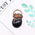 Nahaufnahme des schwarzen ovalen Steinanhängers mit geprägter Kappe aus Bronze - 20x40mm / Schwarzer Achat