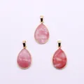 Detailed view of pink natural stone teardrop pendants with polished gold-plated metal frames - Watermelon Quartz
