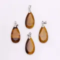Macro view of faceted teardrop tiger eye stone pendants with silver metal clasps - Tiger's Eye