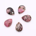 Macro shot of five faceted teardrop pink stone pendants with natural veined textures - Rhodonite with Black Lines