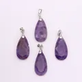 Close-up of four purple teardrop faceted amethyst crystal pendants with silver bails - Amethyst