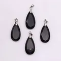 Macro view of four faceted black natural stone teardrop pendants with silver metal clasps - Black Agate