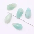 Macro shot of pear-shaped faceted green natural stone beads with fine vertical drill holes - Amazonite