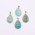 Macro detail of four teardrop-shaped natural blue-green gemstone pendants with silver clasps - Amazonite