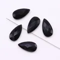 Macro detail of five faceted black teardrop stones strung on a metal pin for DIY jewelry - Black Agate