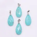 Macro shot of four teardrop-shaped turquoise pendants with faceted textures and silver bails - 13x25mm / Blue Turquoise