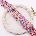 Detailed view of colorful cube beads for DIY jewelry making on white lace background - Multicolor