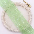 Detail van lichtgroene ovale kattenoog kralen op een elegante kanten decoratie - Lichtgroen