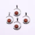 Macro shot of silver sun and crescent moon pendants with red sandstone inlay - Gold Sandstone