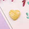 Detalle macro de una cuenta de piedra de mármol amarilla con fondo floral - Patrón Mármol Amarillo Blanco (No.4)